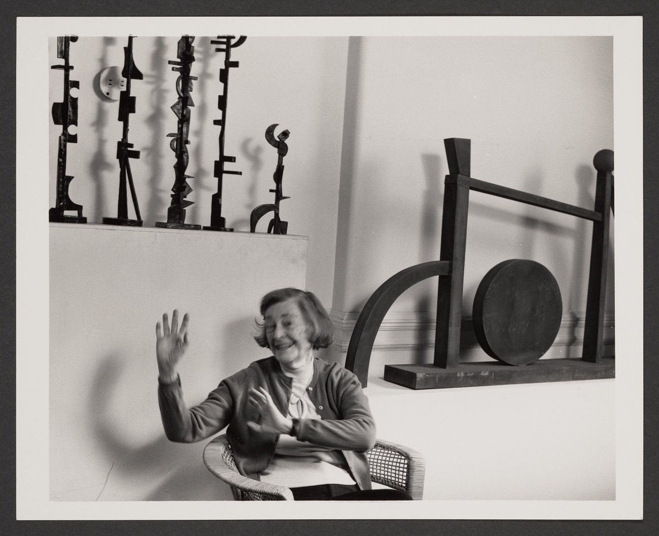 Dorothy Dehner in her studio, laughing, surrounded by her totem sculptures